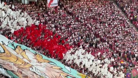 Fans Wave Red and White Flags With Large Banner in Packed Stadium Before Vídeo Stock 336718715
