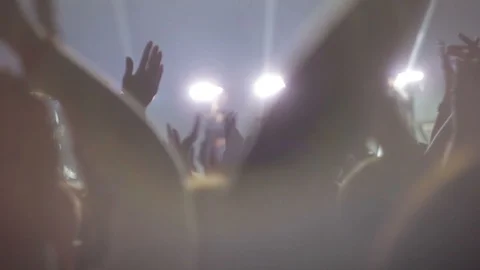 Fans wave their hands to the beat of the music at the concert Stockbeeldmateriaal 91420812