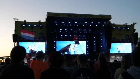 Fans waving flags of Netherlands during Eurovision song sung by Dutch duo Vídeos de archivo 240947216