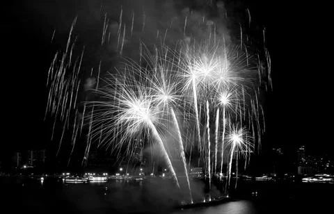 Fantastic fireworks exploding in to a night sky over the bay in monochrome Stock Photos