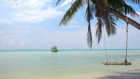 Fantastic idyllic view of tree swing hanging from exotic palm above ocean Stock-Footage 94332952