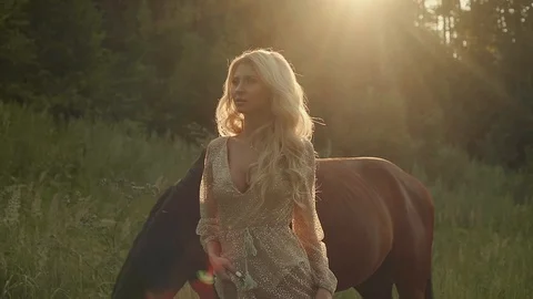 Fantastic model on shooting in summer forest meadow with horse. Video stock 96156476