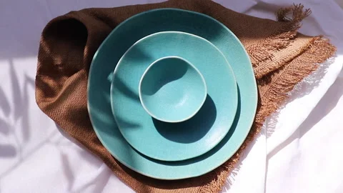 Fantastic turquoise tableware set with lighting from leaves shadow. Stock Footage 140767818