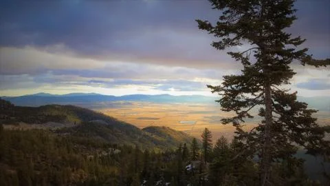 Fantastic view looking down from mountain forest into a beautiful sunlit valley. Stock Photos
