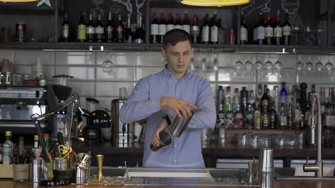 Fantastically beautiful bartender tosses two shakers Stock Footage 102743052