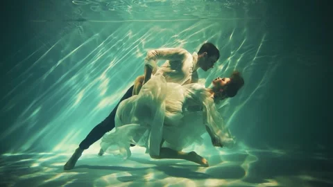 Fantasy couple fall in love man king and woman princess posing underwater dark Stock Footage 311937127