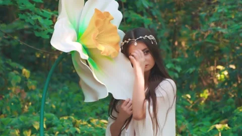 Fantasy woman elf hugging daffodil flower. Renaissance style silver diadem Stock Footage