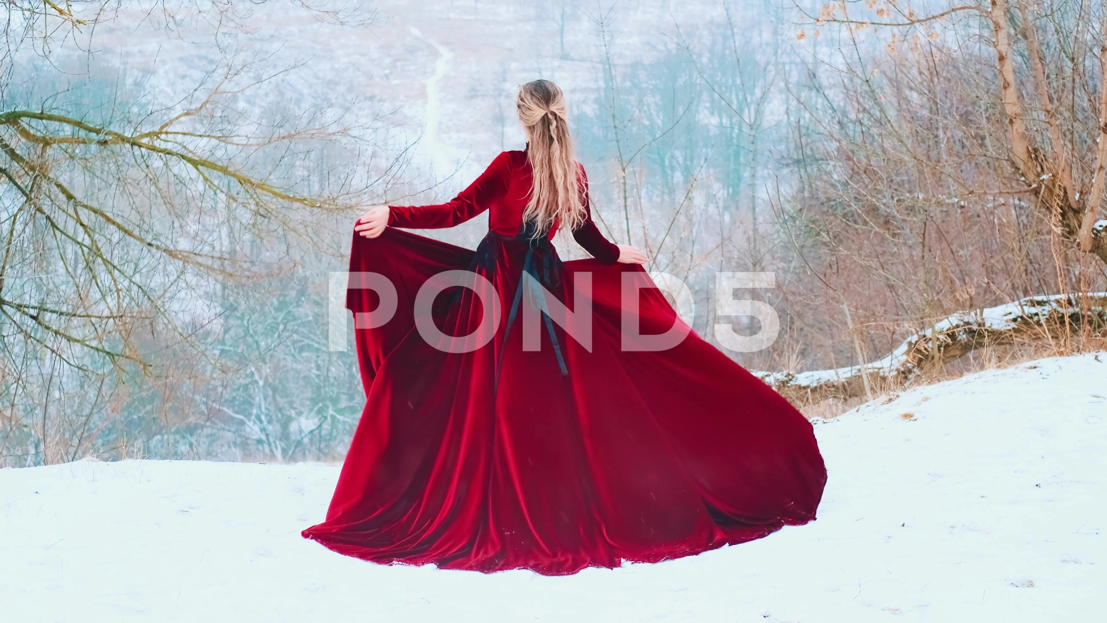 Fantasy woman standing dancing on top of mountain red fabric flies waves in wind Fantasy woman standing dancing on top of mountain red fabric flies waves in wind