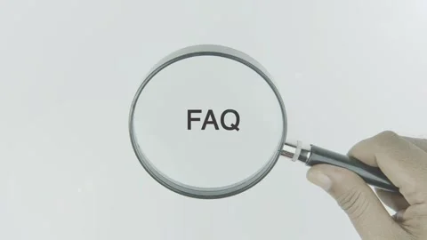 FAQ text or word highlighted by a magnifying glass in a hand on a white Stock Footage 303622914