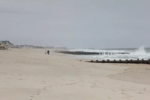 Far Away Couple on a Beach - Overcast and Stormy Stock Photos