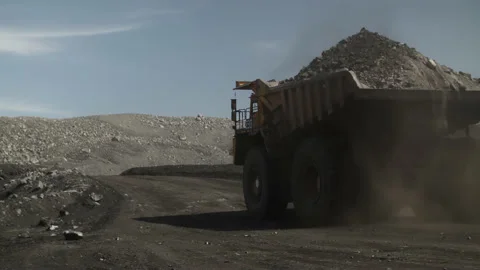 Far away going electric mining dump truck filled with coal. Back view Stock Footage 205245234