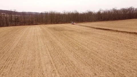 Faraway shot of tractor plowing corn field Stock Footage 266191319