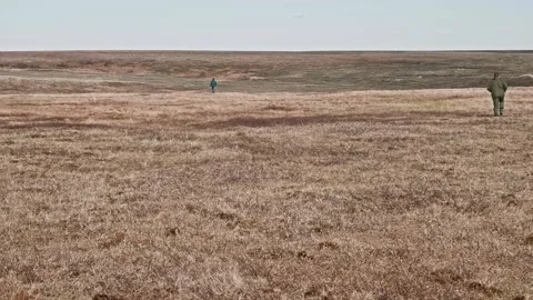 Faraway view of two unrecognizable men running in Tundra. Researchers at work Stock Footage 165768948