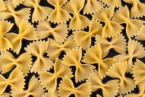 Farfalle pasta pattern on black background, top view, flat lay texture Stock-Fotos