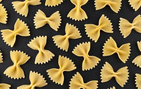 Farfalle pasta pattern on black background, top view, flat lay texture Dry... Stock Photos