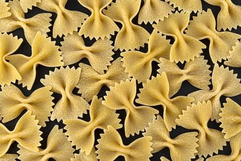 Farfalle pasta pattern on black background, top view, flat lay texture Stock Photos