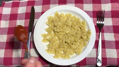 Farfalle with tomato paste on a white plate Stock Footage 106575146
