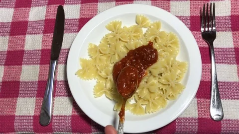 Farfalle with tomato paste on a white plate Video stock 106575165