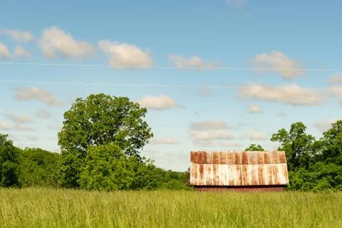 Farm barn falling down ruins abandoned repair in grass field and trees Stock Photos