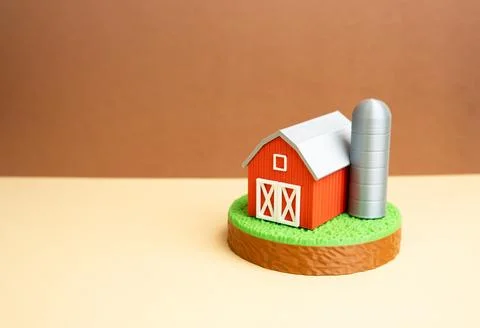 A farm barn with a silo on a plot of green grass. Agribusiness and farming .. 写真素材