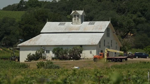 Farm barn warehouse with tractor. Surrounded by green fields C Stock Footage 111578594
