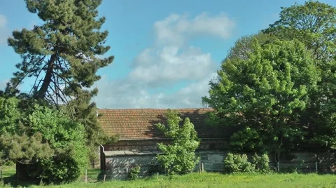 Farm building red tiles moving trees clouds rural Stock Footage 60431896