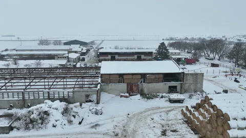 Farm cowshed straw stack bales barn winter frost snow drone aerial building Vídeo Stock 229372699