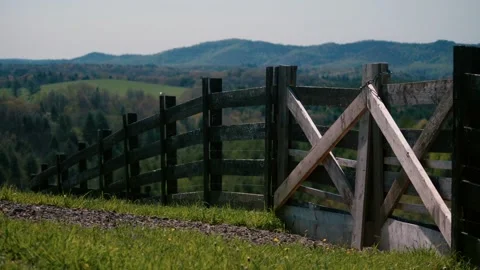 Farm fence going down mountain side with blue ridge mountains in the back Video stock 187564754