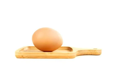 Farm fresh brown egg in a tiny cutting board isolated over white Foto stock