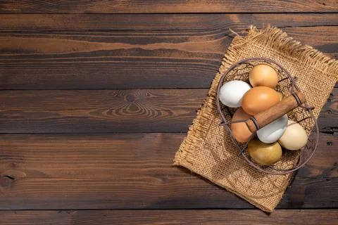 Farm fresh eggs in basket on rustic wooden table Stock Photos