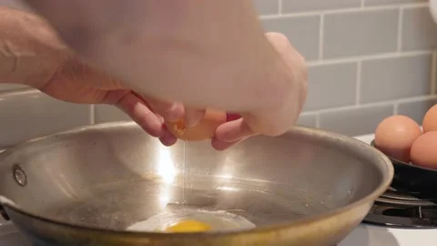 Farm fresh eggs cracking in frying pan, cooking, kitchen. 4K 24FPS. Stock Footage 200995333