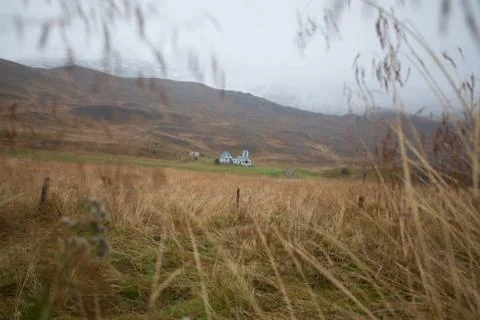 Farm in front of a empty mountain range with fog and snow. Lovely landscape.. Stock Photos