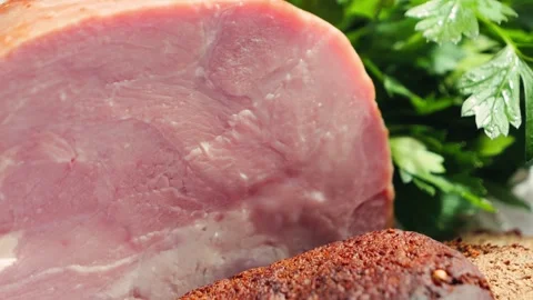 Farm ham close up with rye bread and parsley on wooden cutting board. Concept of Stock Footage 335693561