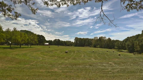 Farm with red barn and round hay bales whispy clouds Video stock 230283036