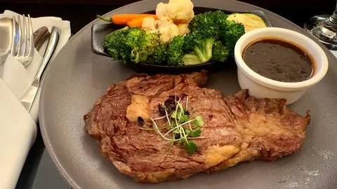 Farm-to-table feast featuring big steak with fresh vegetable salad, topped with Stock Photos