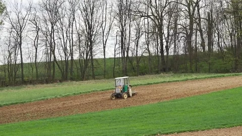 Farm tractor harrowing arable field 库存影片 271380408