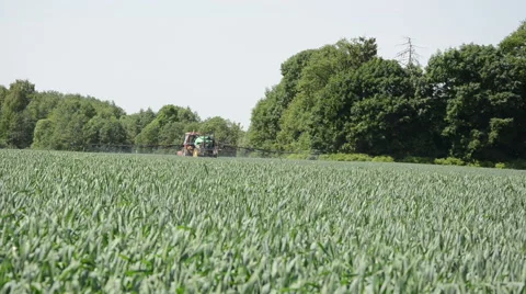 Farm tractor with long spray atomizer on field Stock Footage 50100316
