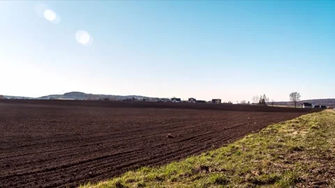 Farm tractor plowing arable field Stockbeeldmateriaal 304631373