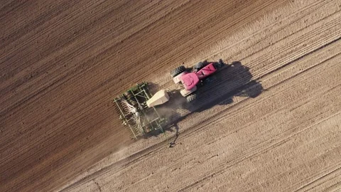 Farm Tractor Plowing Soil Ground Before Planting Crop In Agricultural Field Stock Footage 147874971