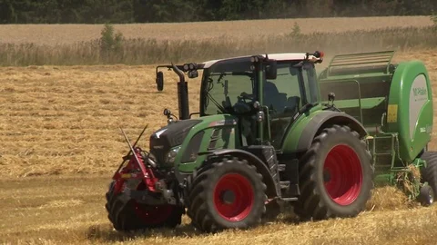 Farm tractor producing straw bales u-turn Stock Footage 78089306