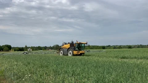 Farm tractor spraying field 動画素材 203827754