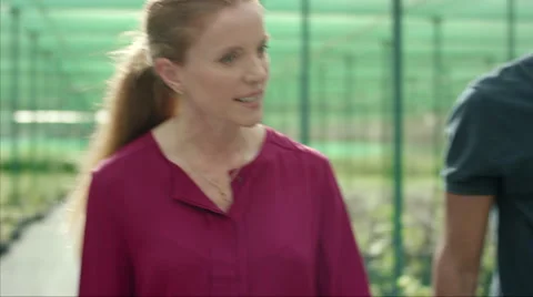 Farm worker with customer analyzing plants at plant nursery. Stock Footage 64029791
