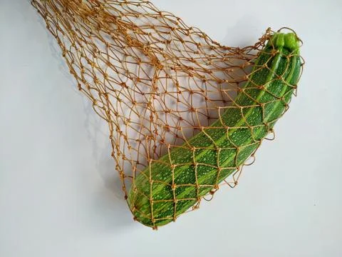 Farm zucchini from the garden in a string bag isolated on a white background Stock Photos