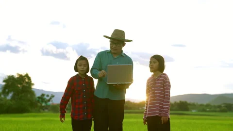Farmer and kid looking rice field on sunset for learning outdoor from family 動画素材 203765298