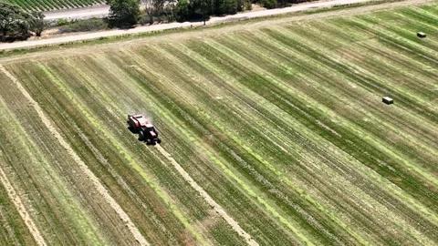 Farmer baling square hay or straw with a tractor. Drone and Tractor. Video stock 199835077