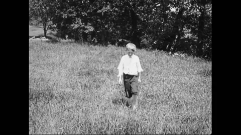 Farmer Boy Walking Barefoot On Grass Examines His Toes 스톡 동영상 130723633