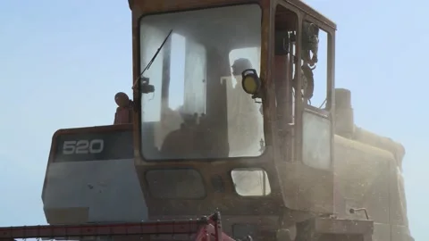 A farmer in the cab of his tractor harvests a wheat field, in France Stock Footage 208059042