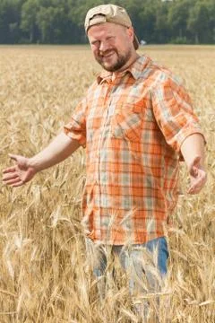 Farmer in cap standing at field Stock Photos
