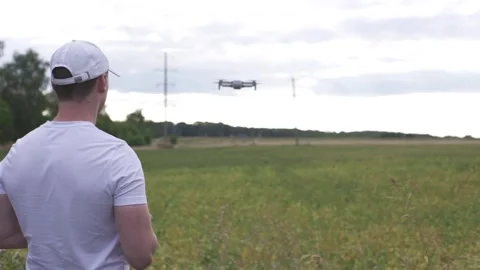 Farmer in a cap uses a drone to fly over a field of soybean. Stock Footage 137972653
