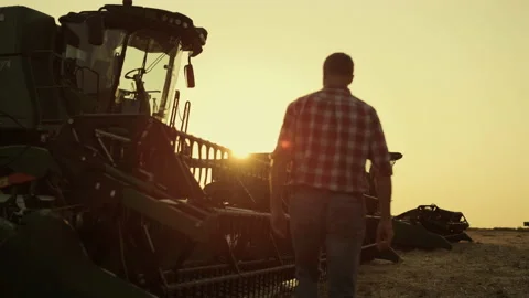 Farmer checking combine working on rye golden countryside field producing wheat Stock Footage 203891463